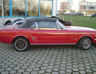 Ein Aufnahme eines roten Ford Mustang Oldtimer von der Seite.